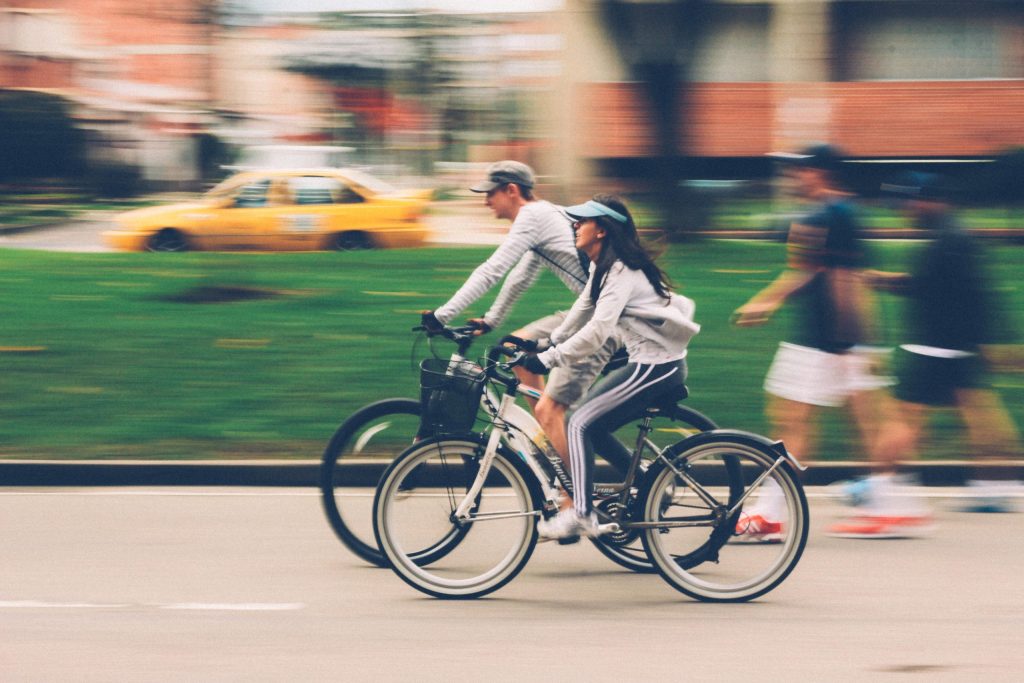 Two people cycling through the city 